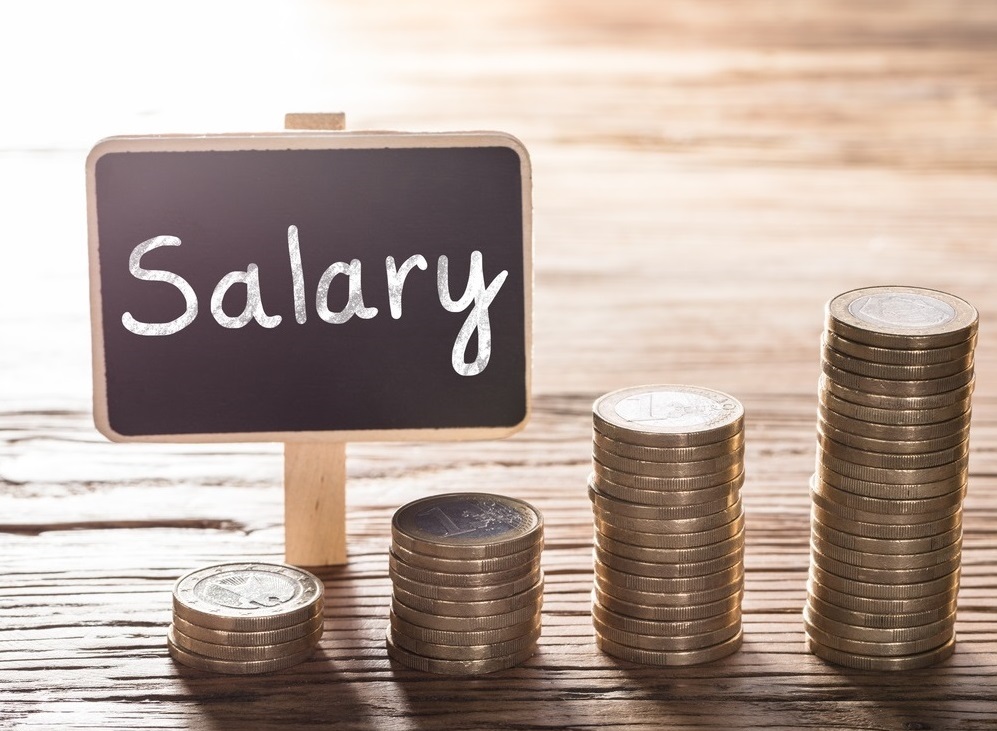 Salary text on small chalk board with coin stack