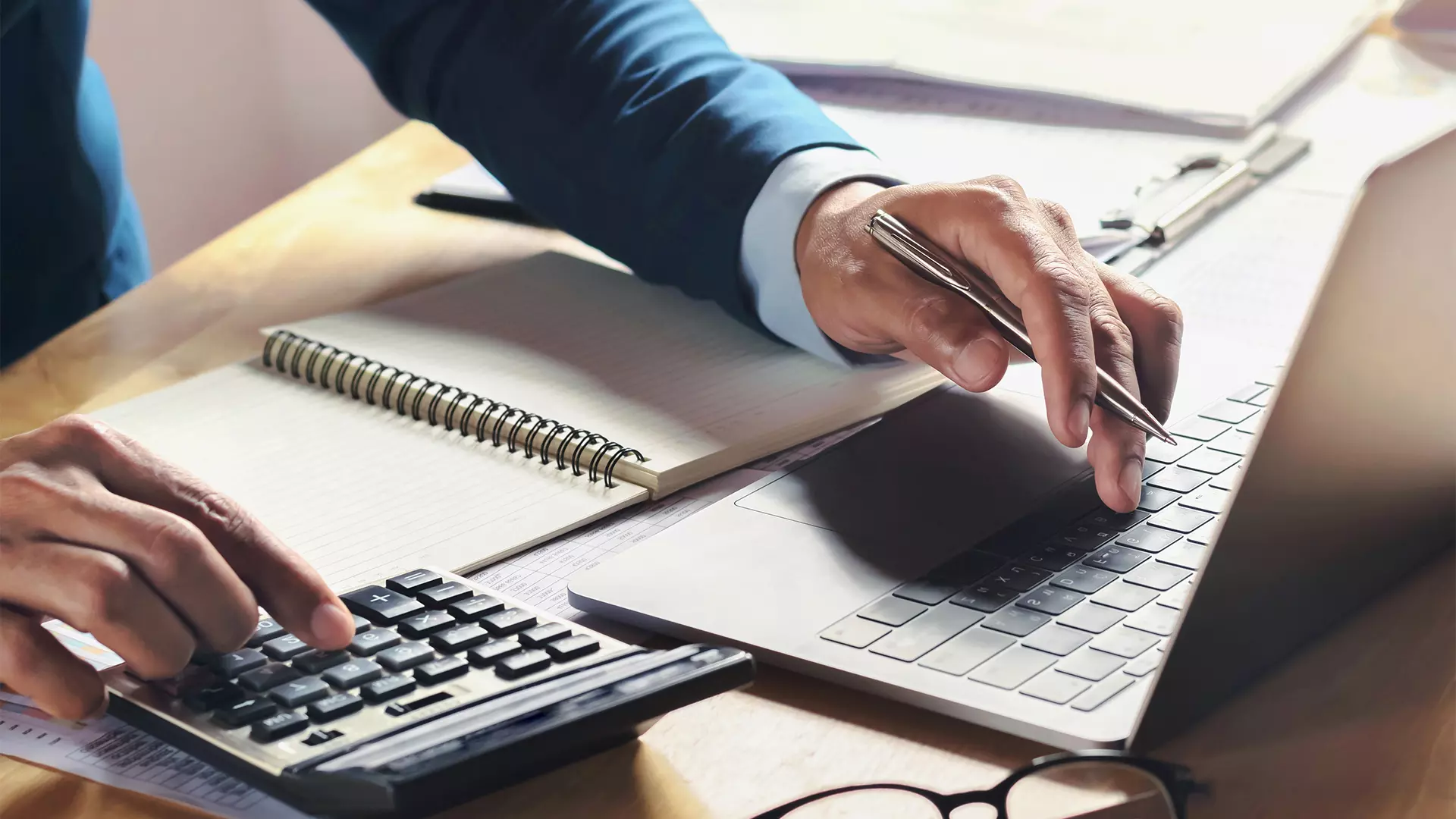 Anyconv.com businessman working on desk with using calculator and computer in office